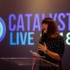 Helen Coffey speaking in front of an illuminated Catalyst Live logo