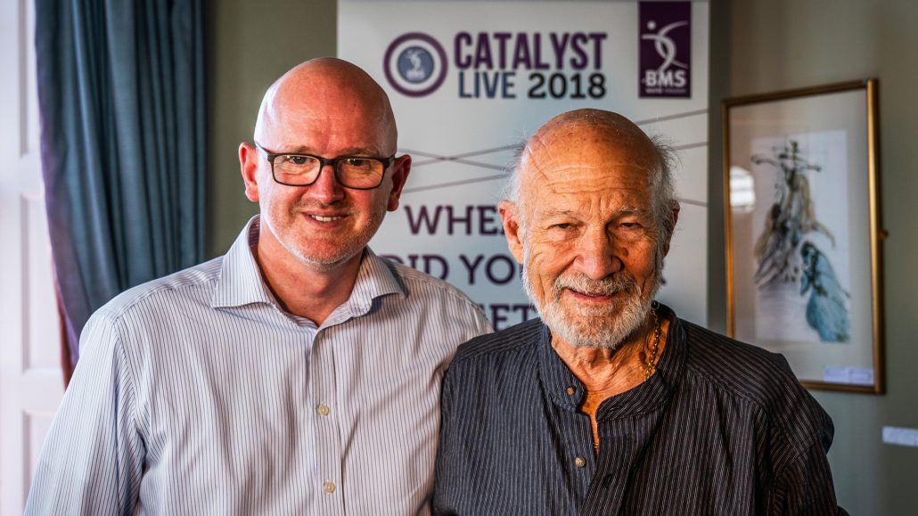 Mark Ord and Stanley Hauerwas in front of a Catalyst Live banner